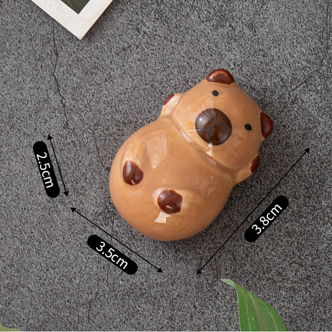 Small brown kawaii animal-shaped object with measurements on a gray surface