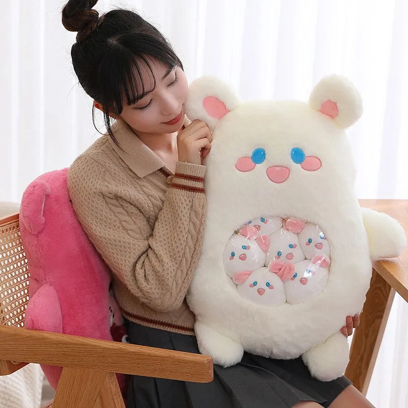 Woman holding a large white kawaii plush toy with pink accents in a bright room.