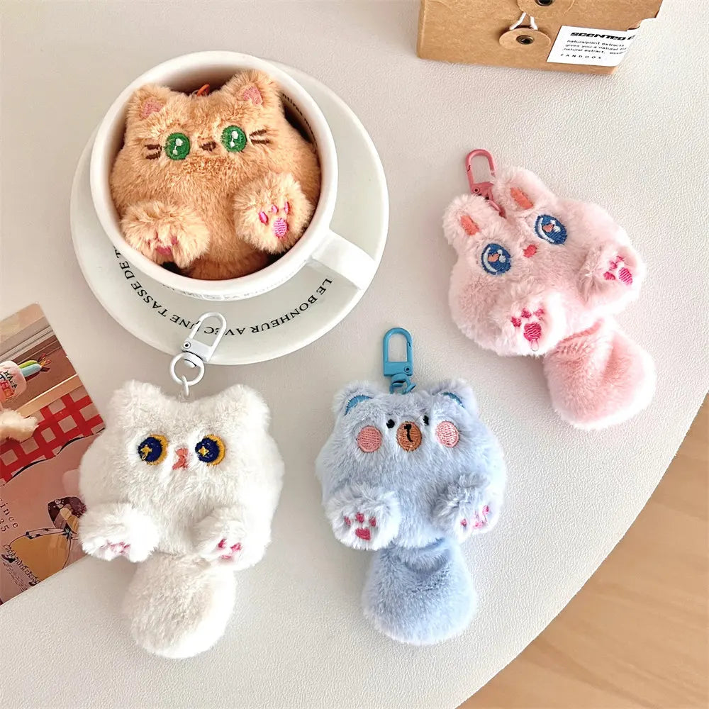 Plush kawaii keychains shaped like animals on a light surface