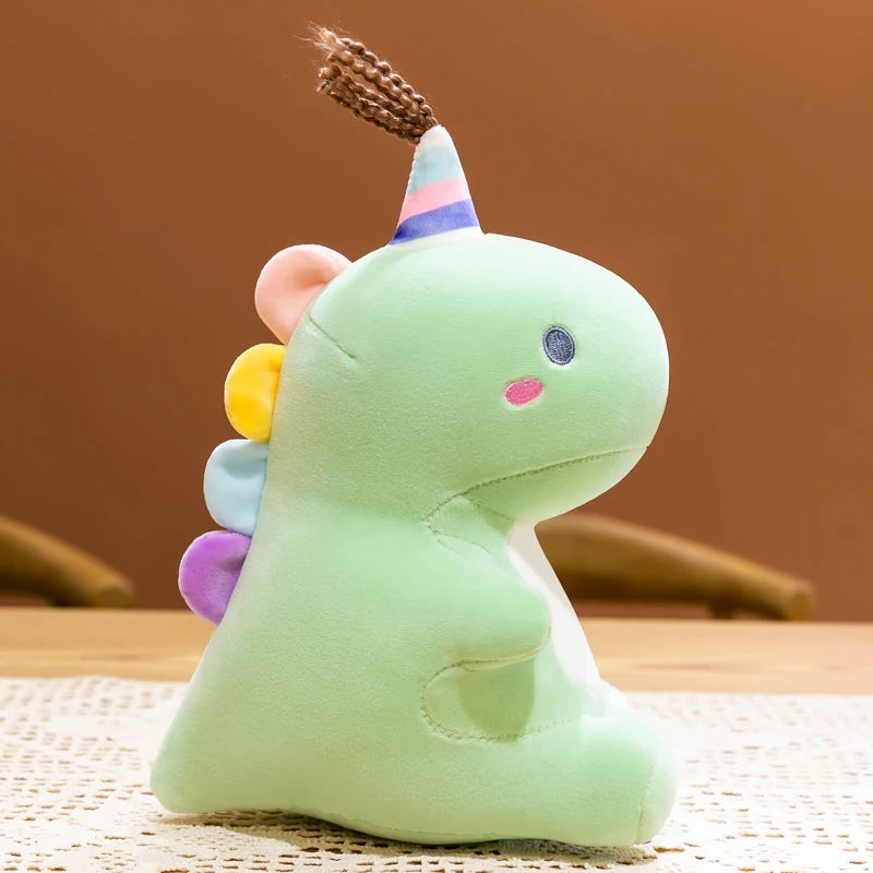 Green dinosaur kawaii plush toy with colorful horn on a woven mat