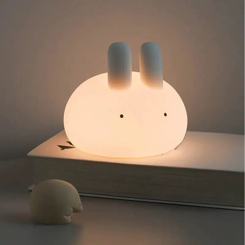 Cute rabbit-shaped kawaii night light on a book with a soft glow