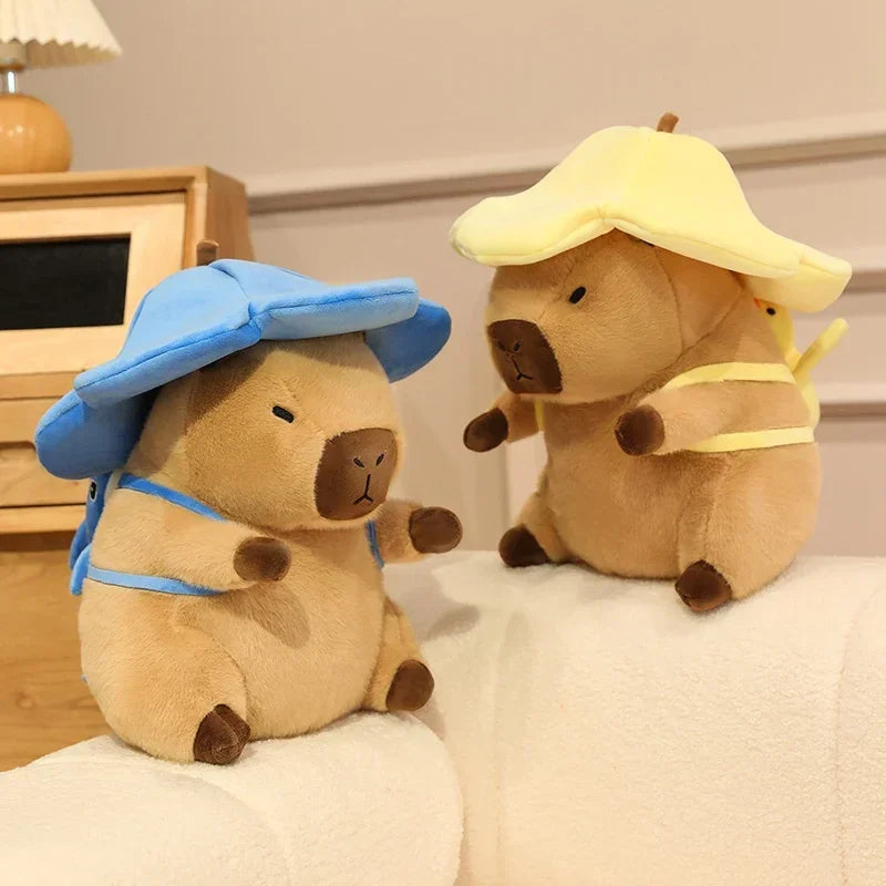 Two kawaii plush toys resembling bears wearing hats on a bed.