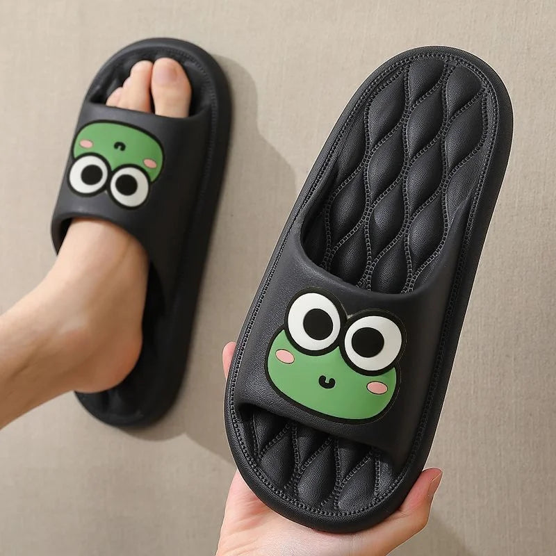 Black slippers with cartoon frog kawaii design on a beige background