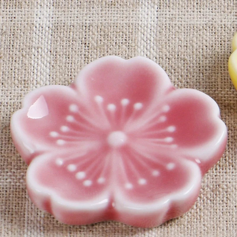 Pink ceramic kawaii flower-shaped object on a textured beige background