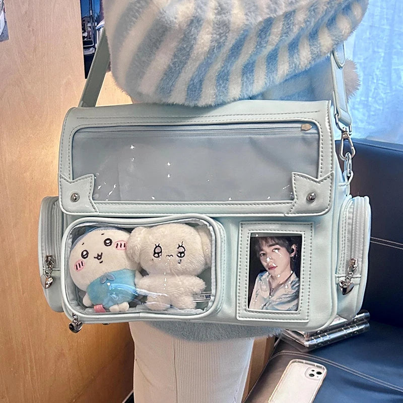 Clear handbag with Kawaii stuffed toys and a photo frame held by a person wearing a striped sweater.