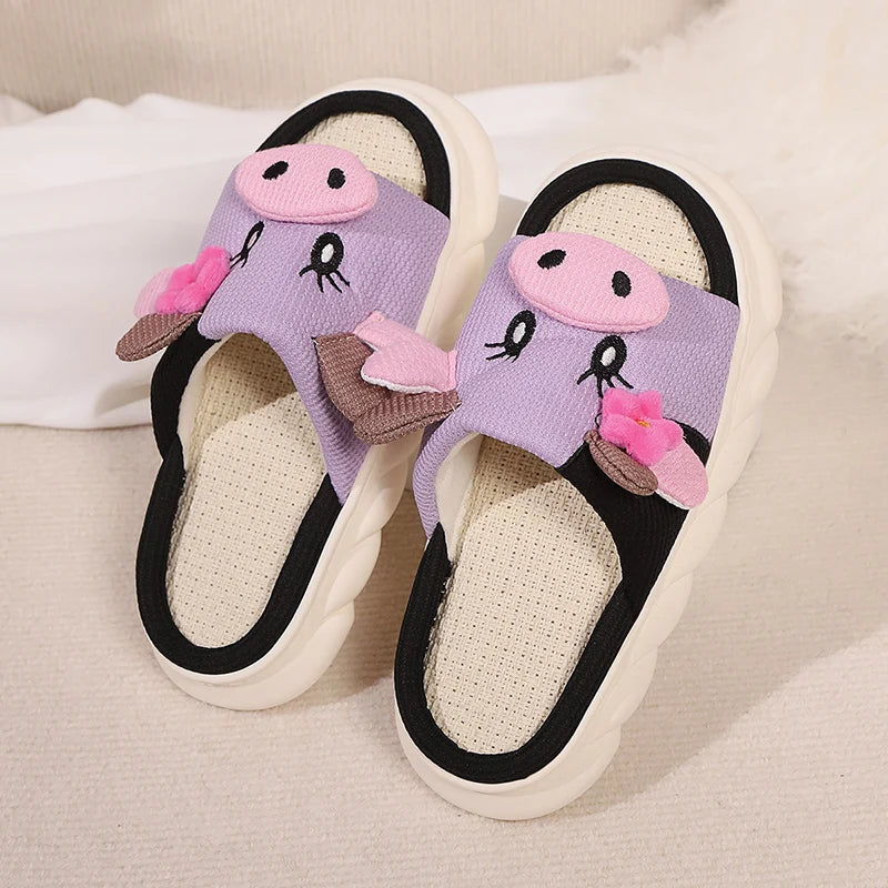 Pair of children's slippers with kawaii cartoon face design on a light background