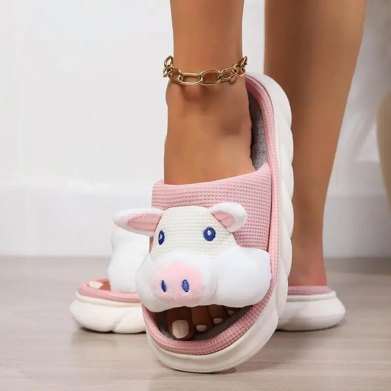 Pink cow-themed kawaii slippers worn by a person on a light background