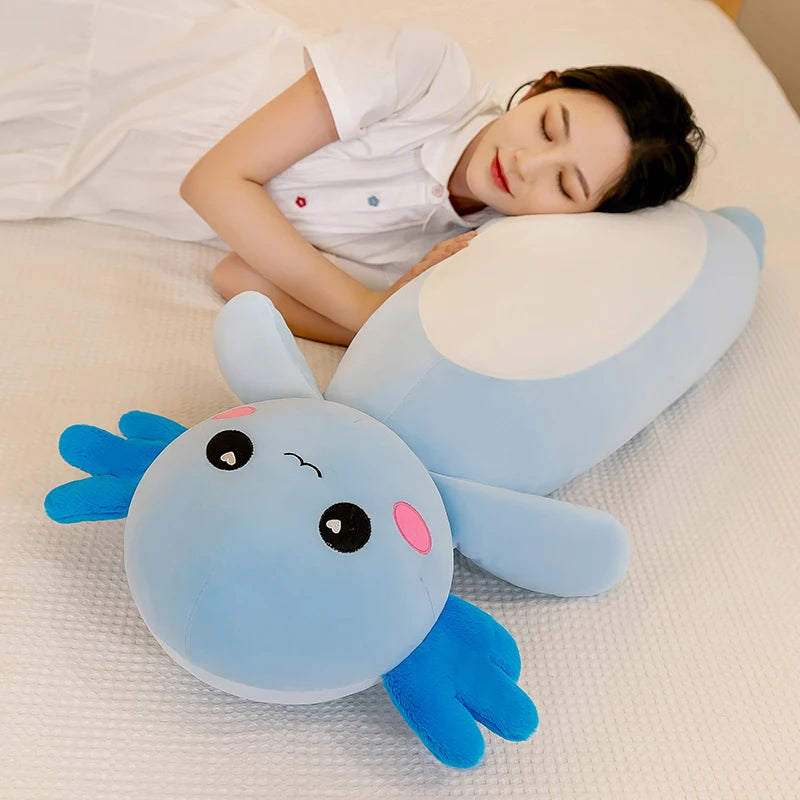 Person lying on a bed with a blue cartoonish kawaii pillow