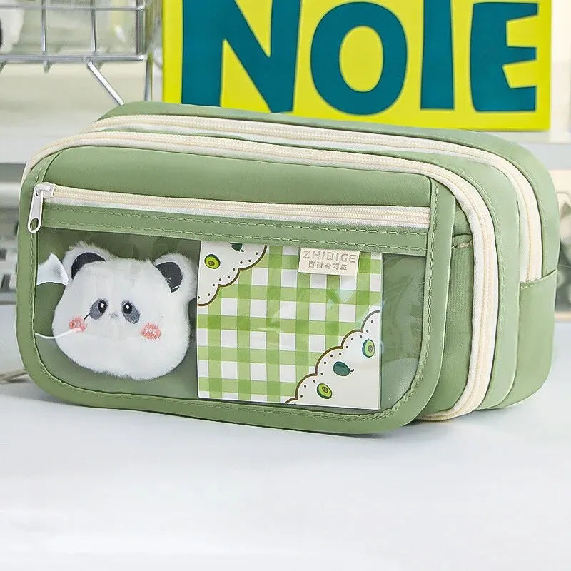 Green pouch with a small kawaii plush toy inside, on a white surface.