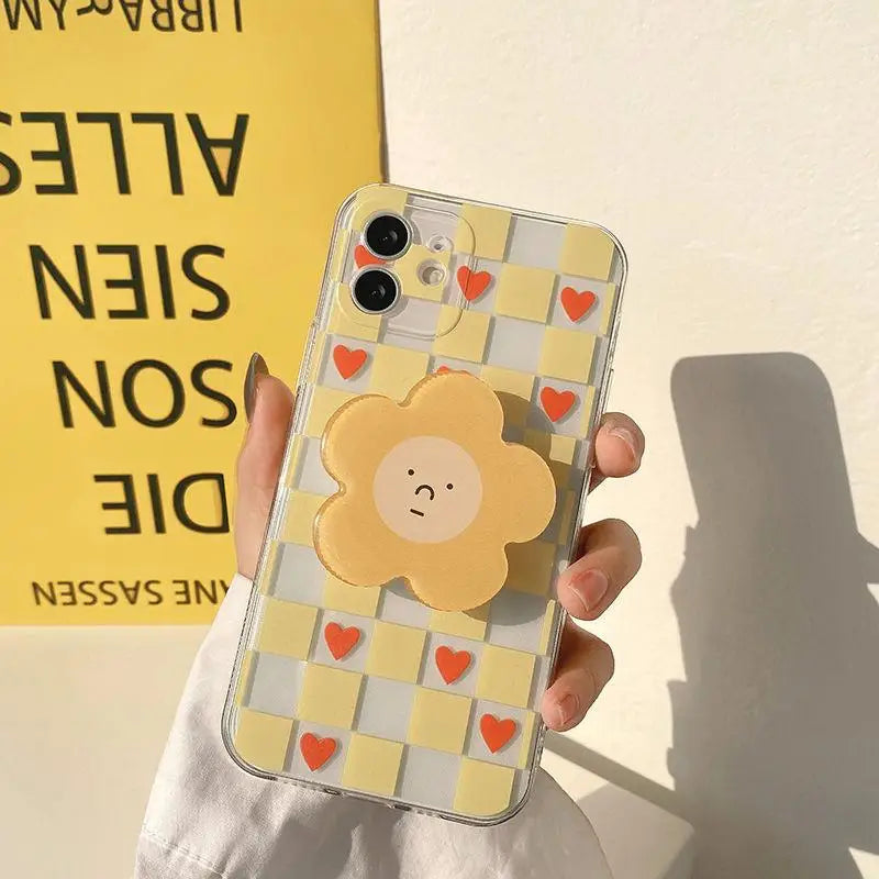 Phone case with a kawaii cartoon sun design held by a hand against a yellow background with text.
