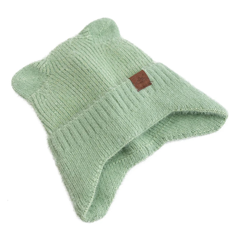 Green knit Kawaii beanie with a brown label on a white background