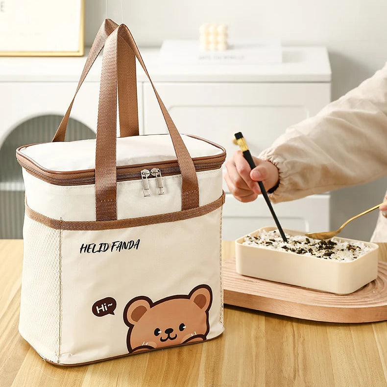 Insulated bag with kawaii bear design next to a person eating from a bowl on a wooden table.