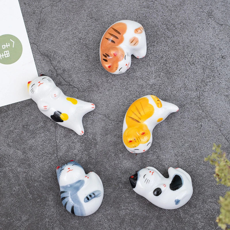 Set of kawaii cat-shaped ceramic magnets on a gray surface