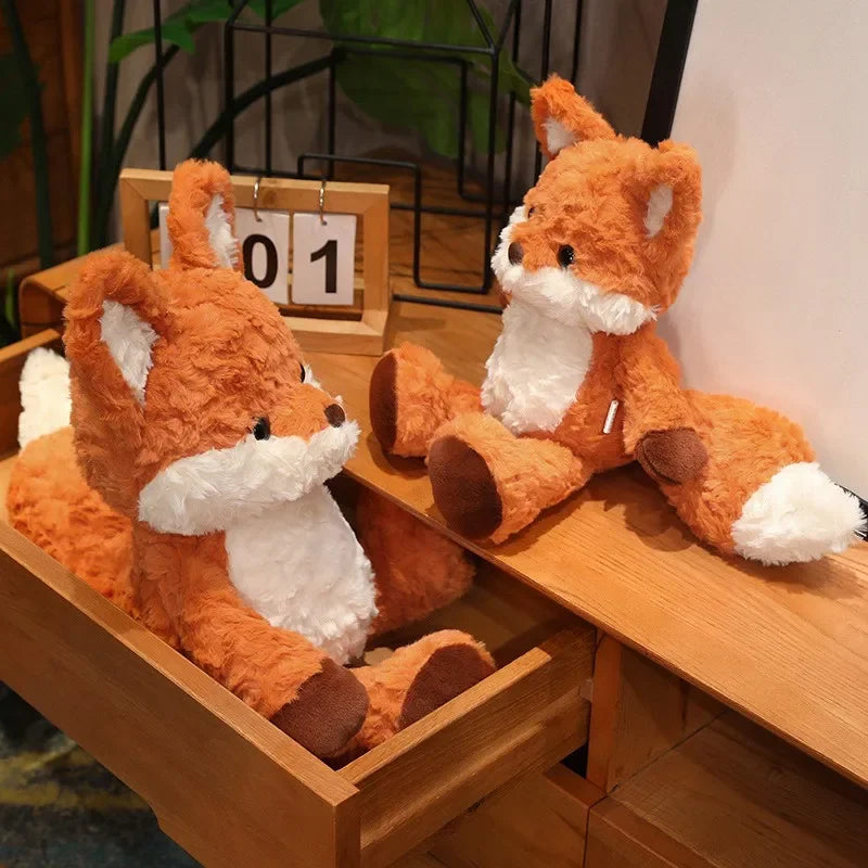 Two plush fox kawaii toys sitting on a wooden surface with a calendar in the background.