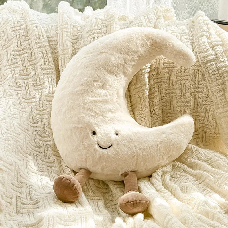 Kawaii plush moon-shaped pillow with a smiling face on a textured blanket