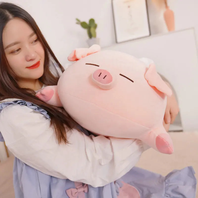 Woman holding a large pink pig kawaii plush toy in a room with a plant and framed picture.