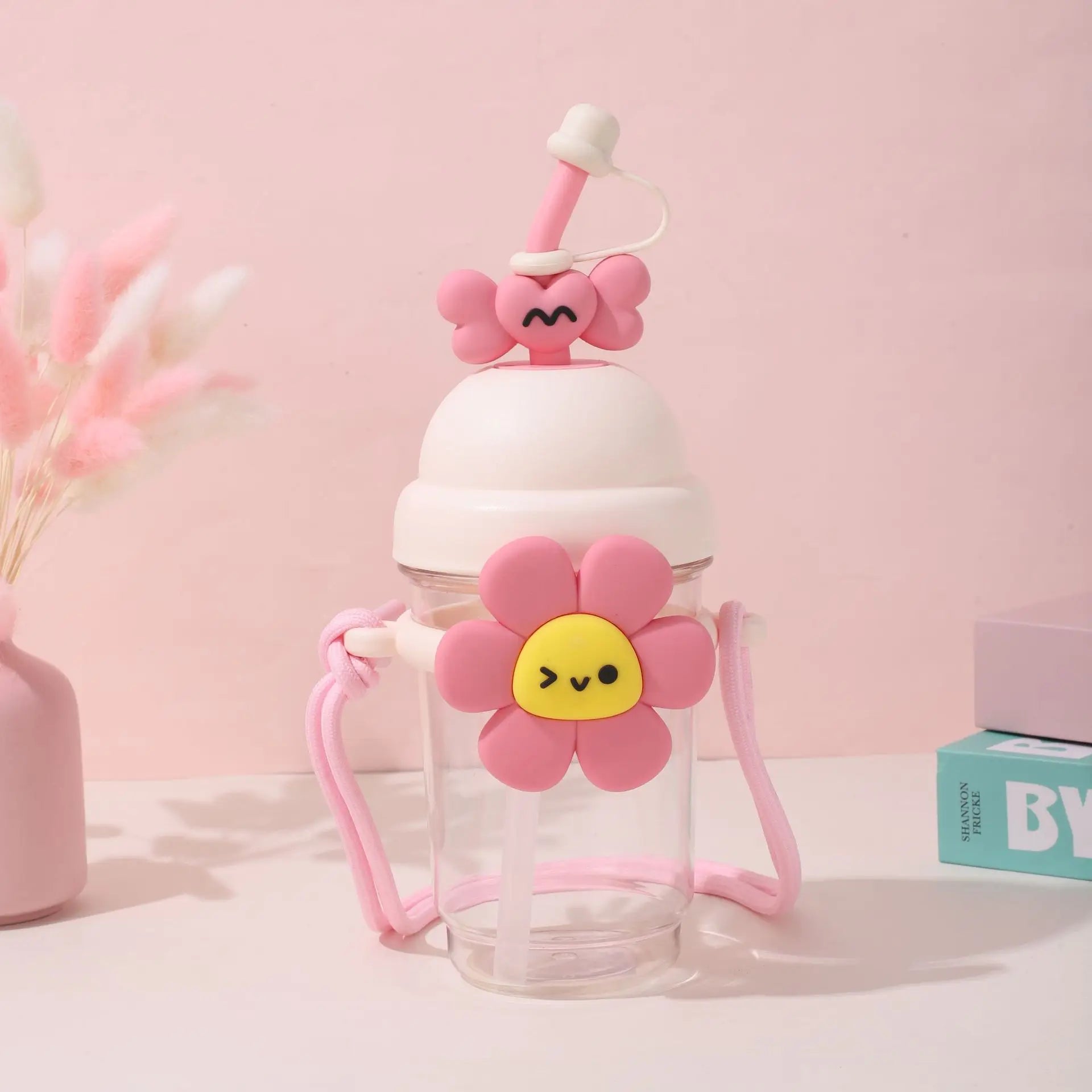 Pink Kawaii cartoon-style water bottle with a flower design on a pink background