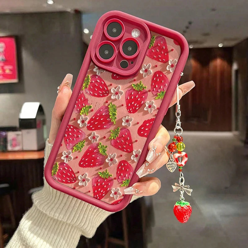 Phone case with kawaii strawberry design held by a hand in an indoor setting