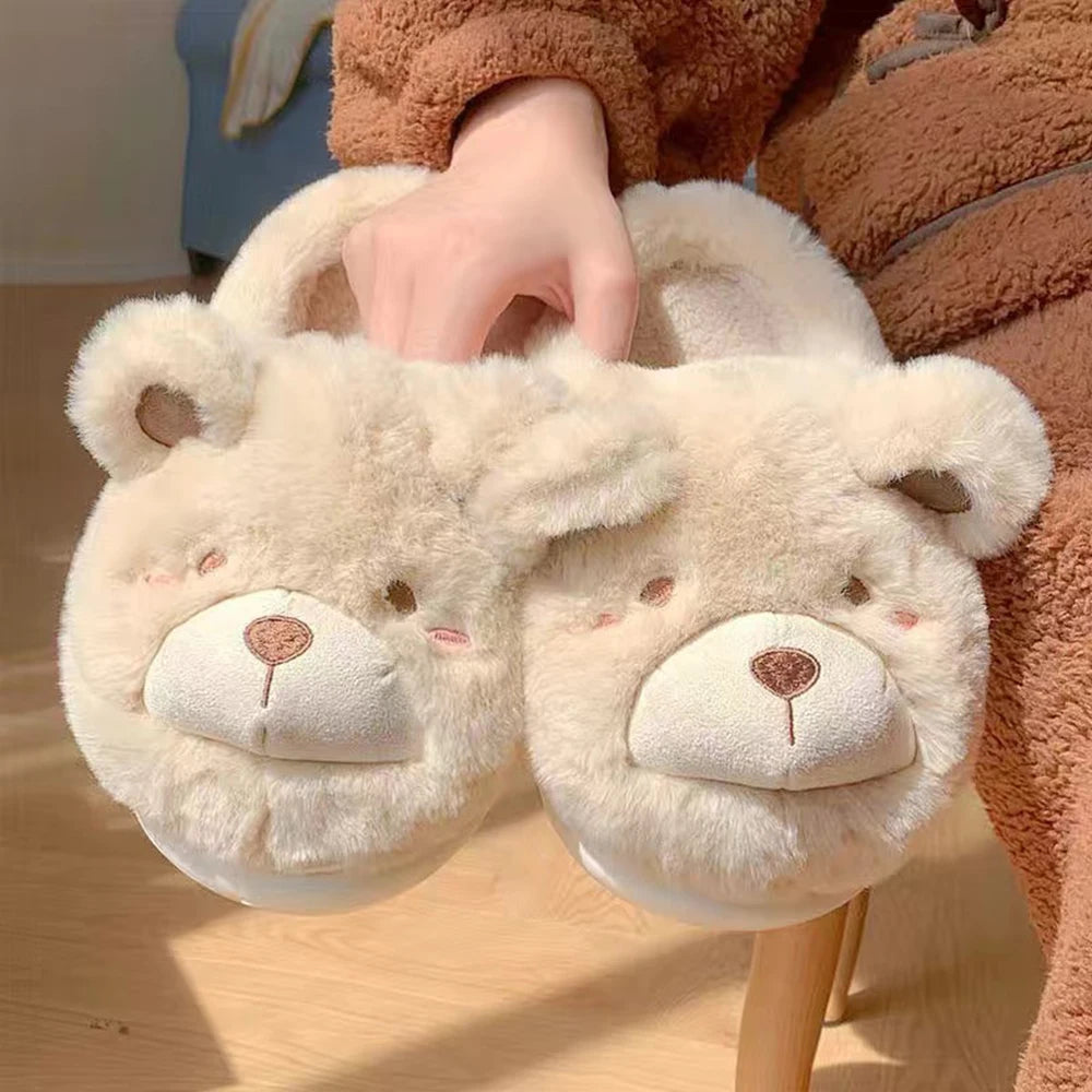 Pair of fluffy bear kawaii slippers held by a person wearing a brown outfit.