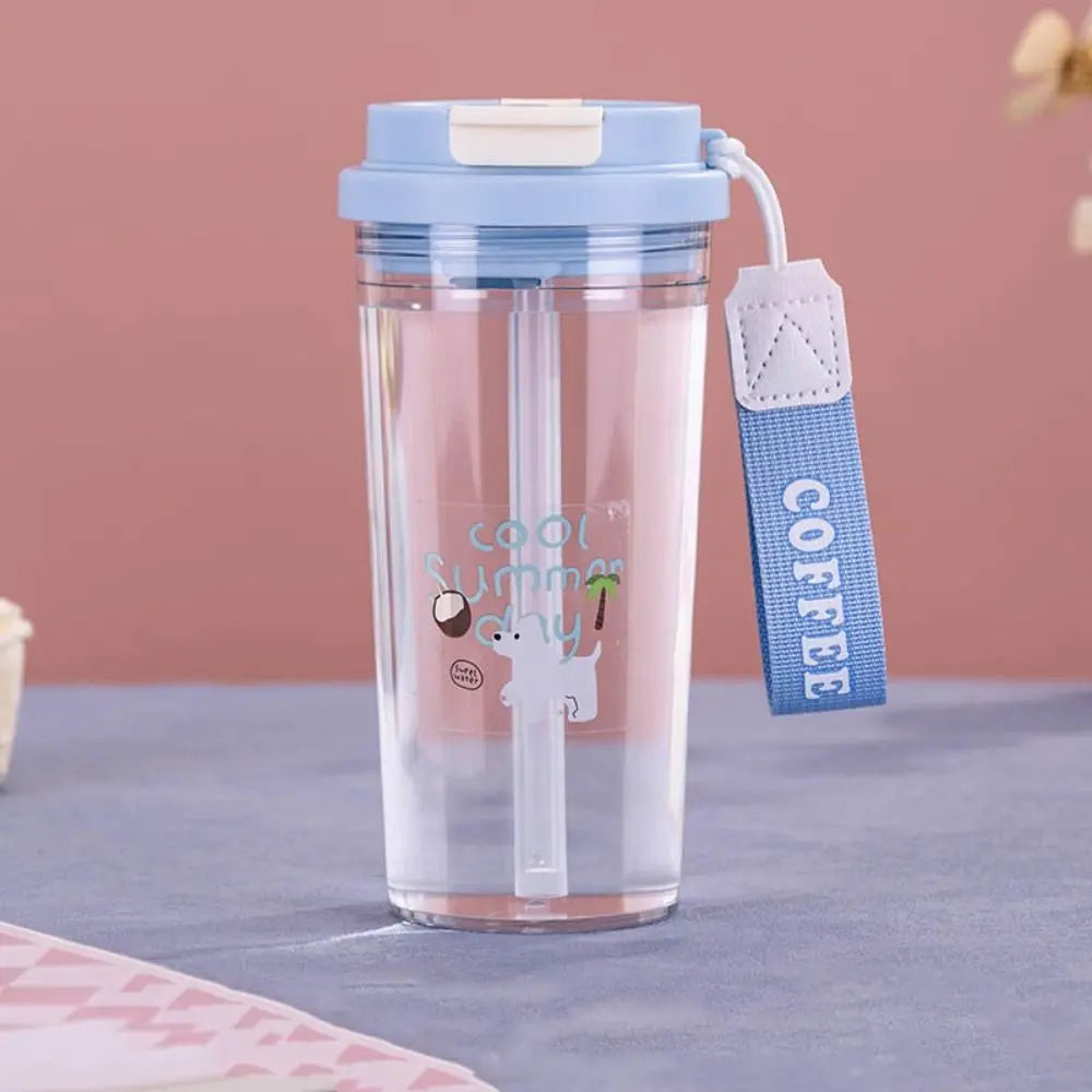 Clear Kawaii-style tumbler with blue lid and strap on a pink background