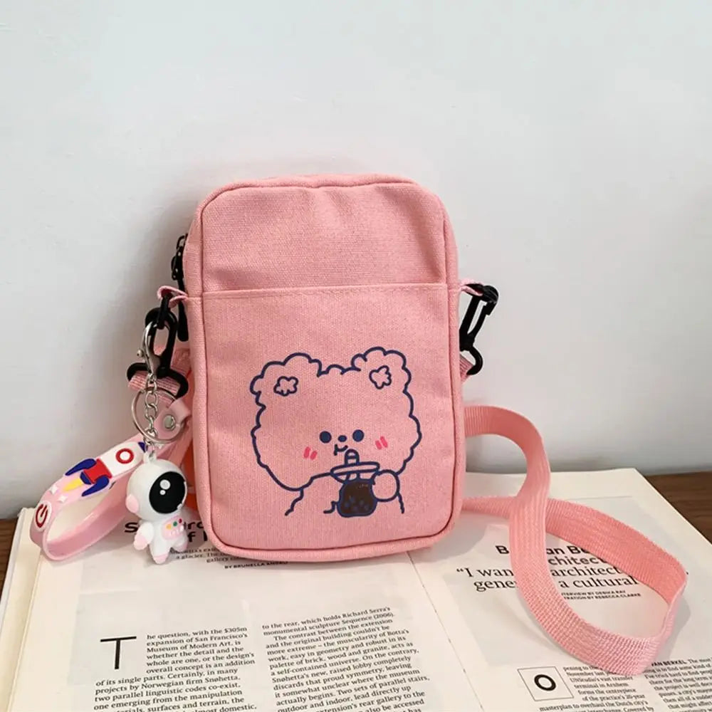 Pink crossbody bag with Kawaii cartoon character design on a book