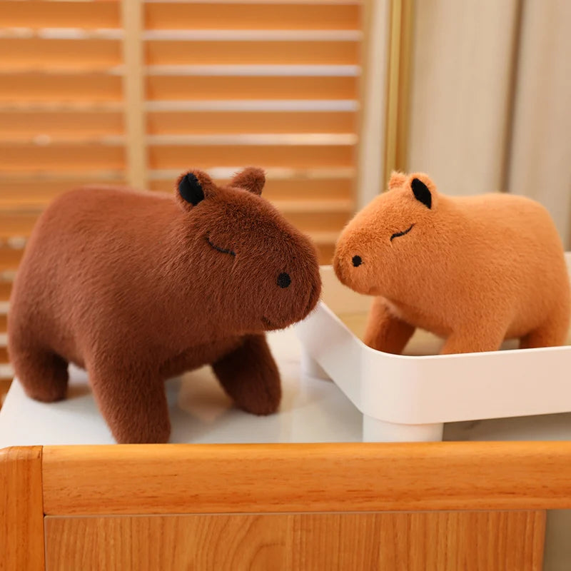 Two kawaii plush hippo toys on a wooden surface with a striped background