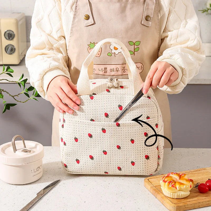 Person holding a white bag with kawaii red patterns on a kitchen counter.