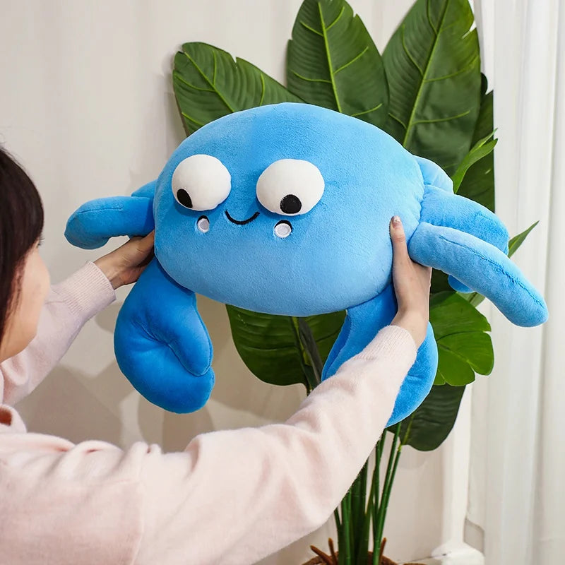 Person holding a blue kawaii plush toy with a plant in the background