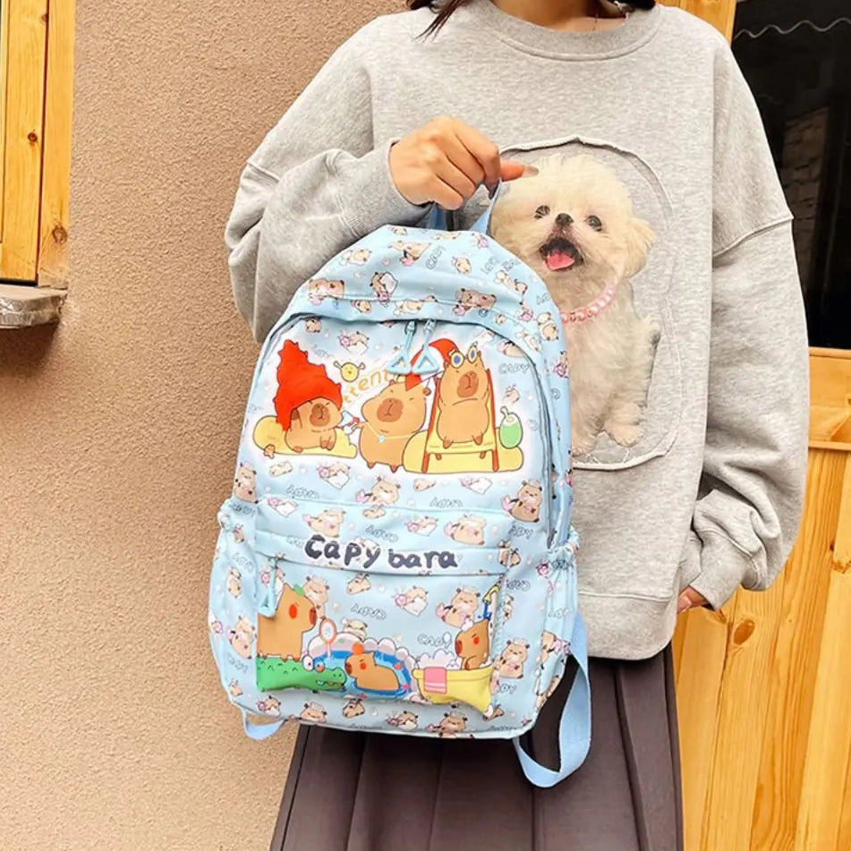 Person holding a Kawaii colorful backpack featuring cartoon characters.