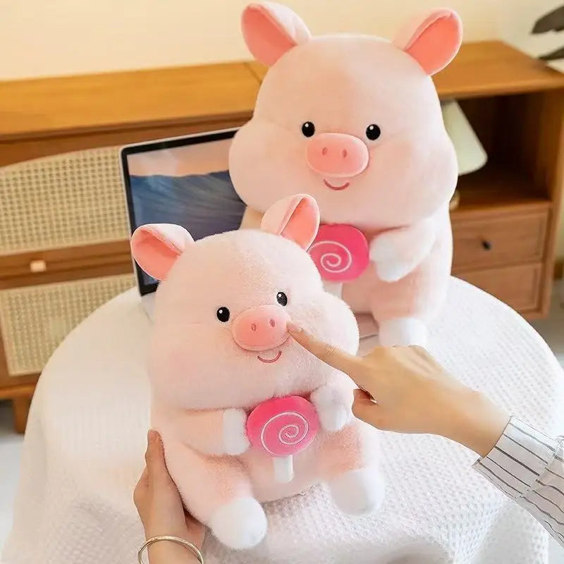 Two pink kawaii plush pigs with a lollipop on a person's lap.