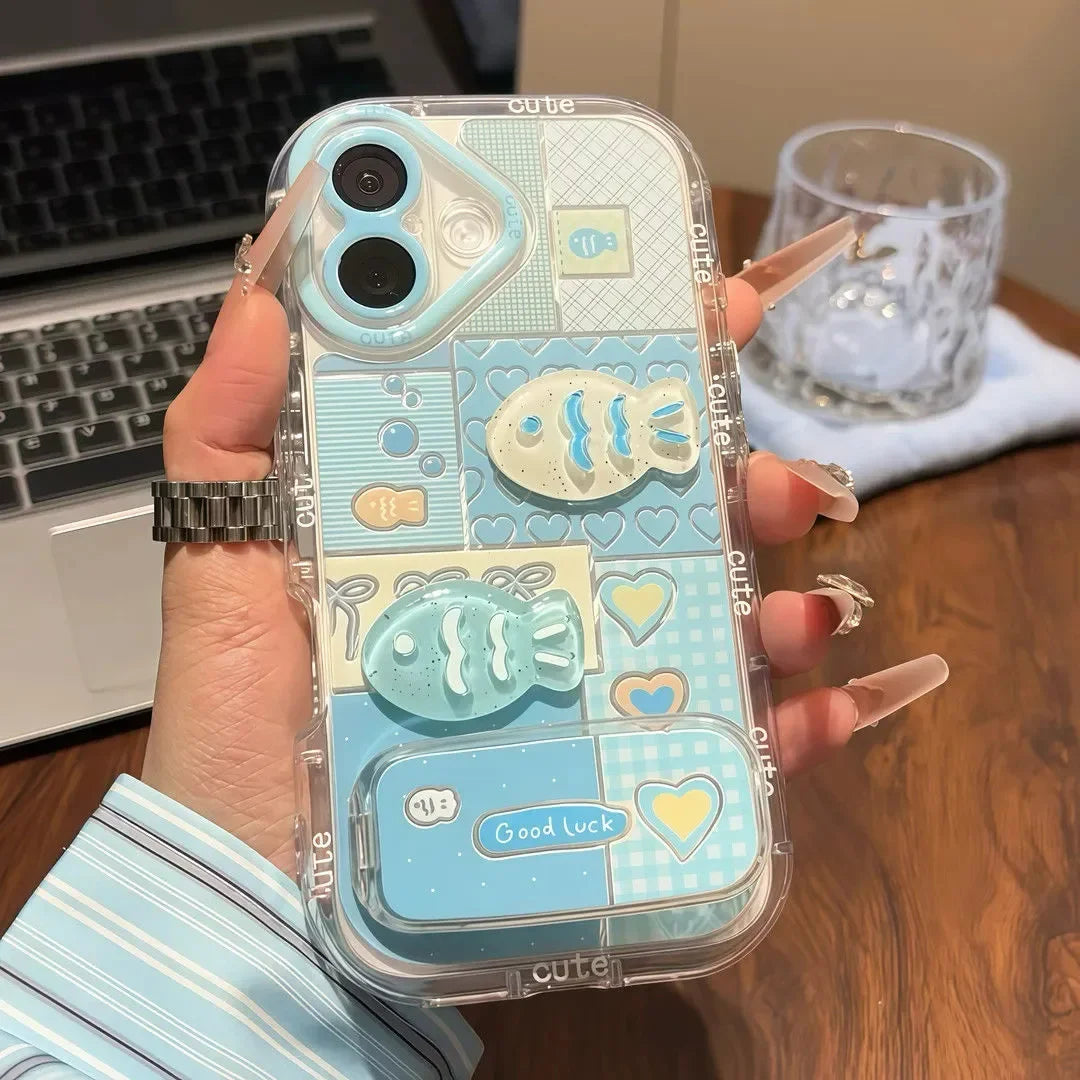 Phone case with kawaii fish design held by a hand on a desk