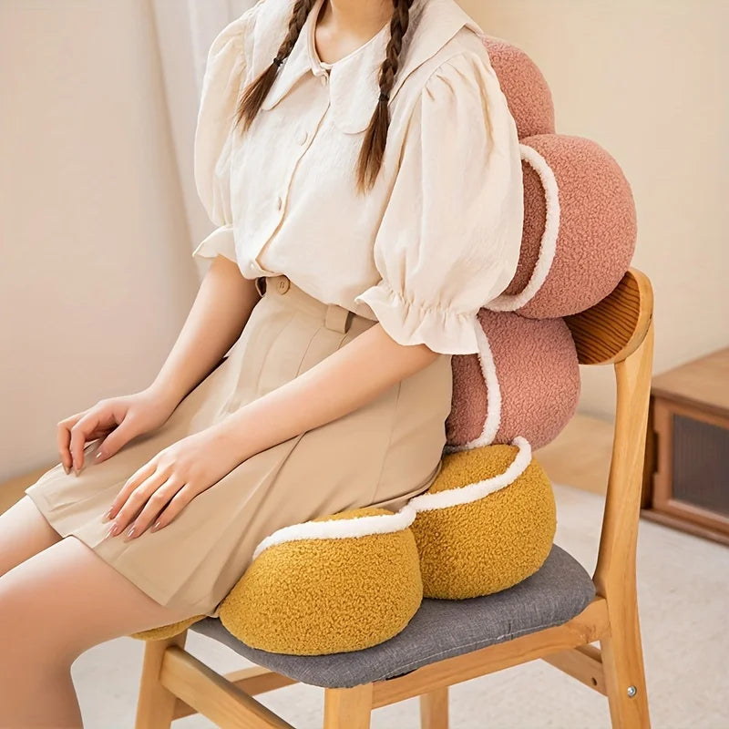 Person sitting on a chair with a colorful kawaii cushion