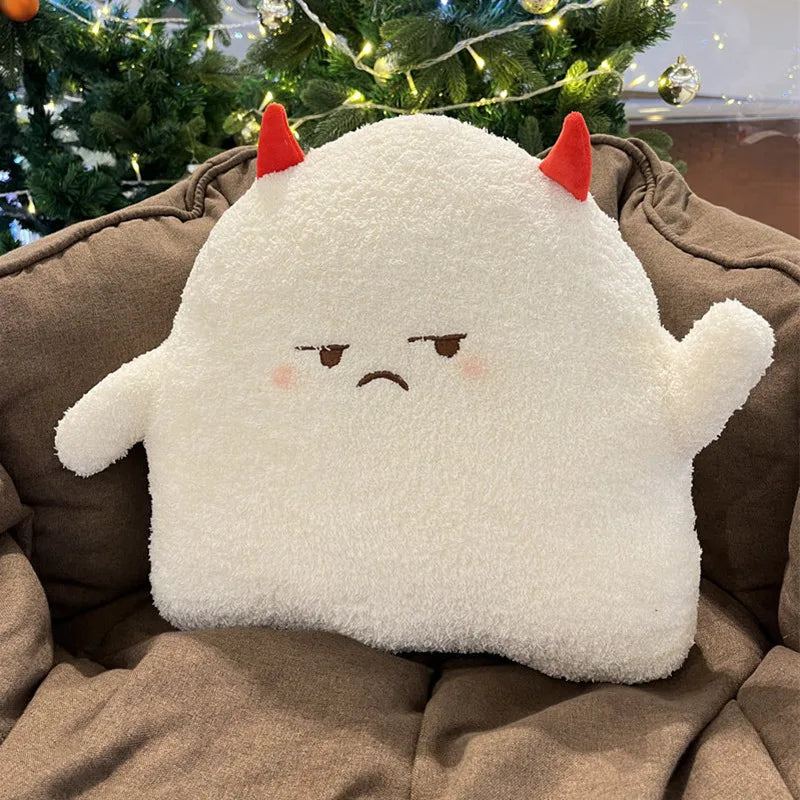Kawaii plush toy with a sad face and red horns on a brown couch with a Christmas tree in the background