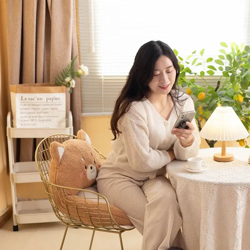 Woman sitting at a table using a kawaii cushion