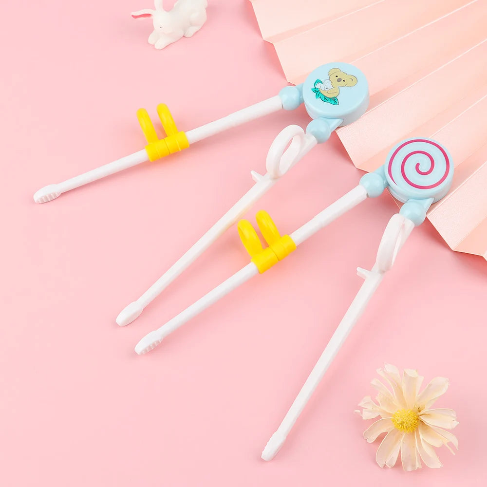 Children's chopsticks with kawaii cartoon ends on a pink background