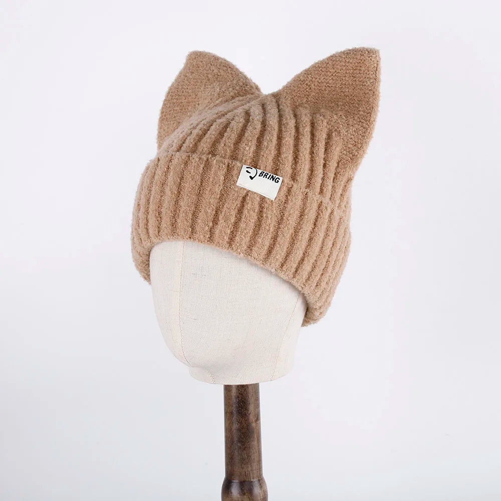 Beige knit Kawaii hat with cat ears on a mannequin head against a white background