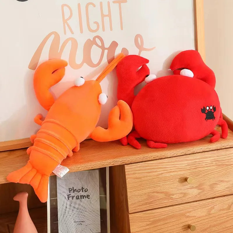 Two kawaii plush toys, one orange and one red, on a wooden surface with a decorative sign in the background.