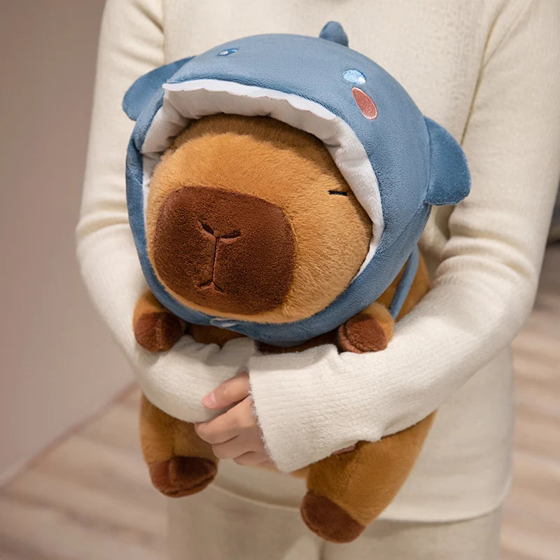 Person holding a kawaii plush toy with a blue shark helmet