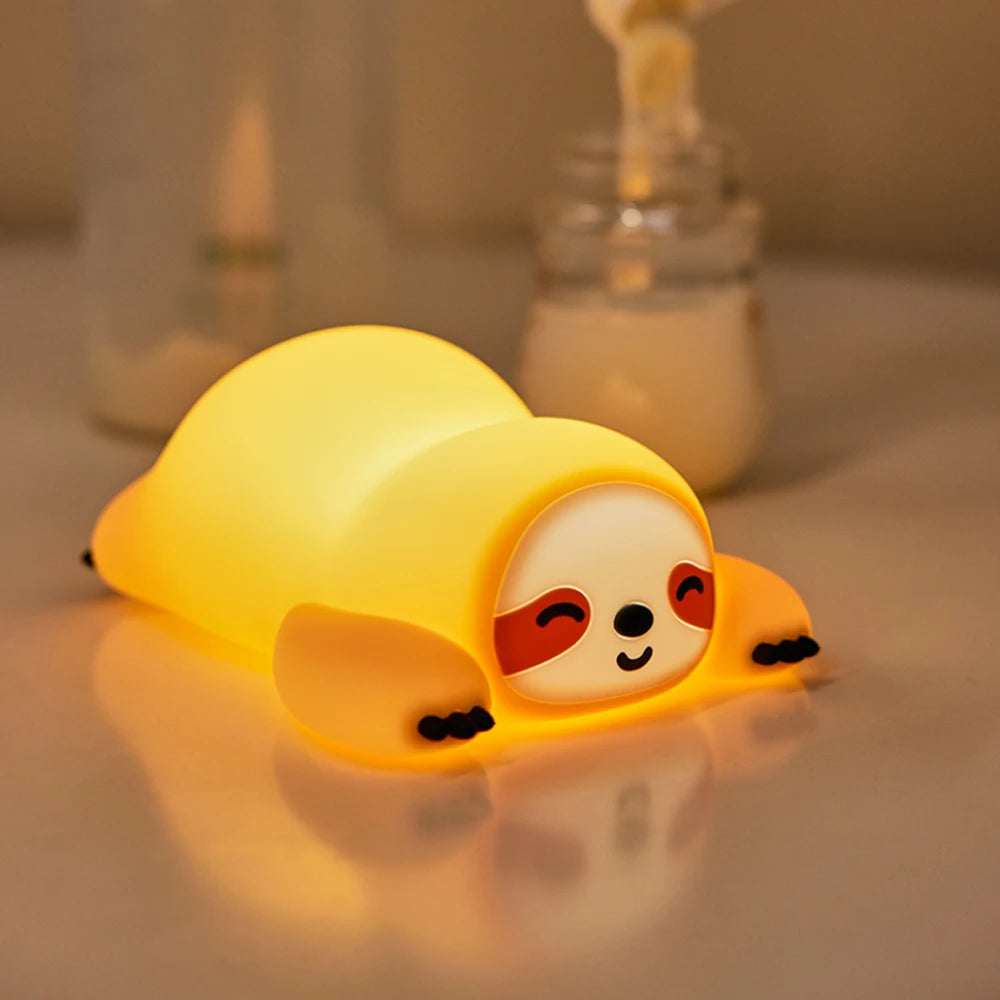 Yellow silicone seal-shaped kawaii night light on a reflective surface with bottles in the background