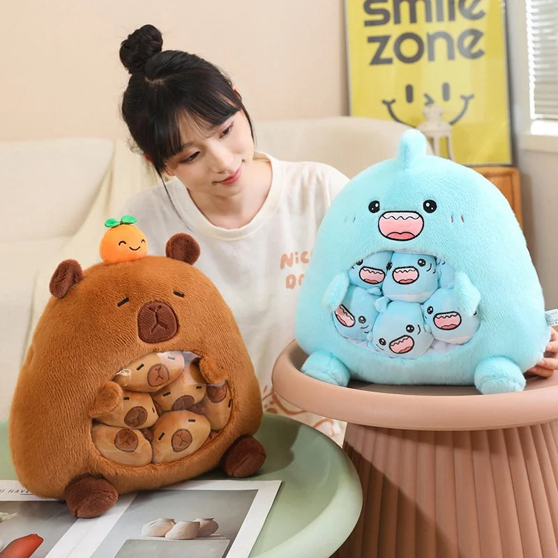 Woman holding a blue kawaii plush toy with multiple faces on a table, with another plush toy resembling a bear in the foreground.