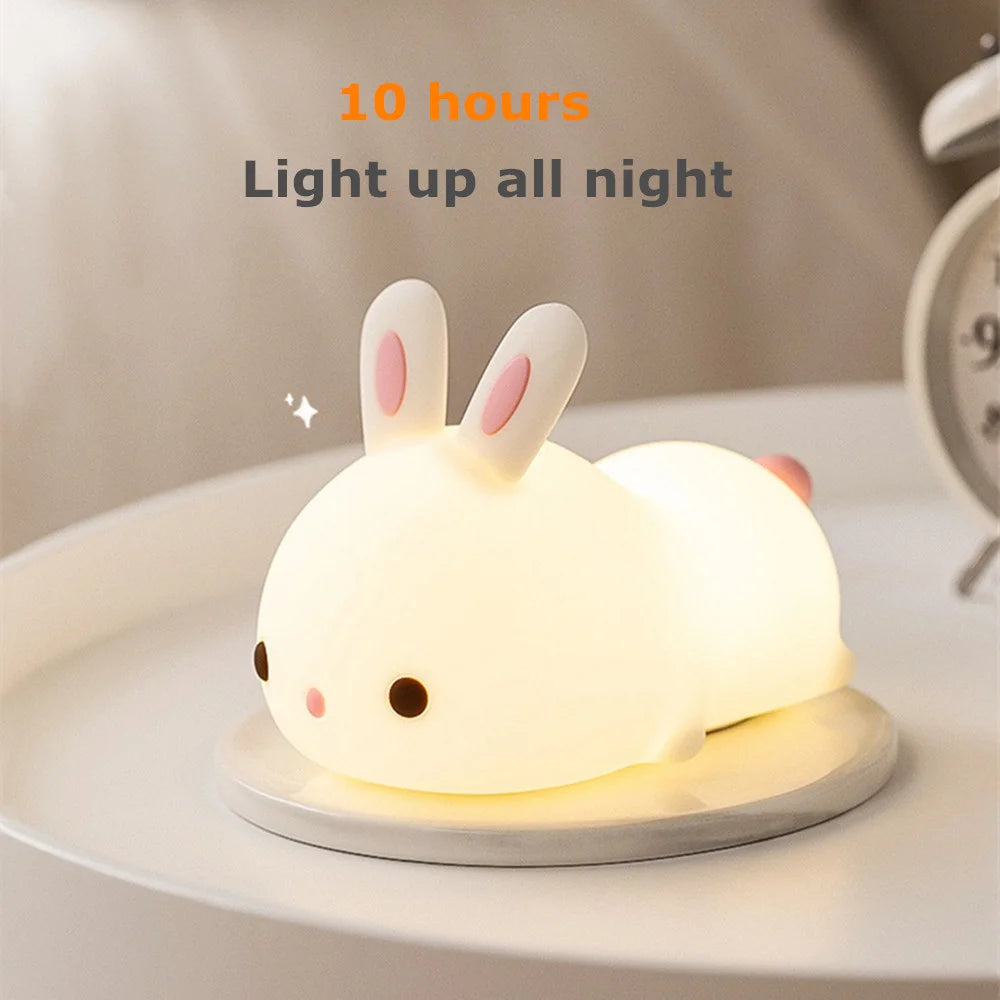 Cute rabbit-shaped kawaii night light on a surface with a clock in the background
