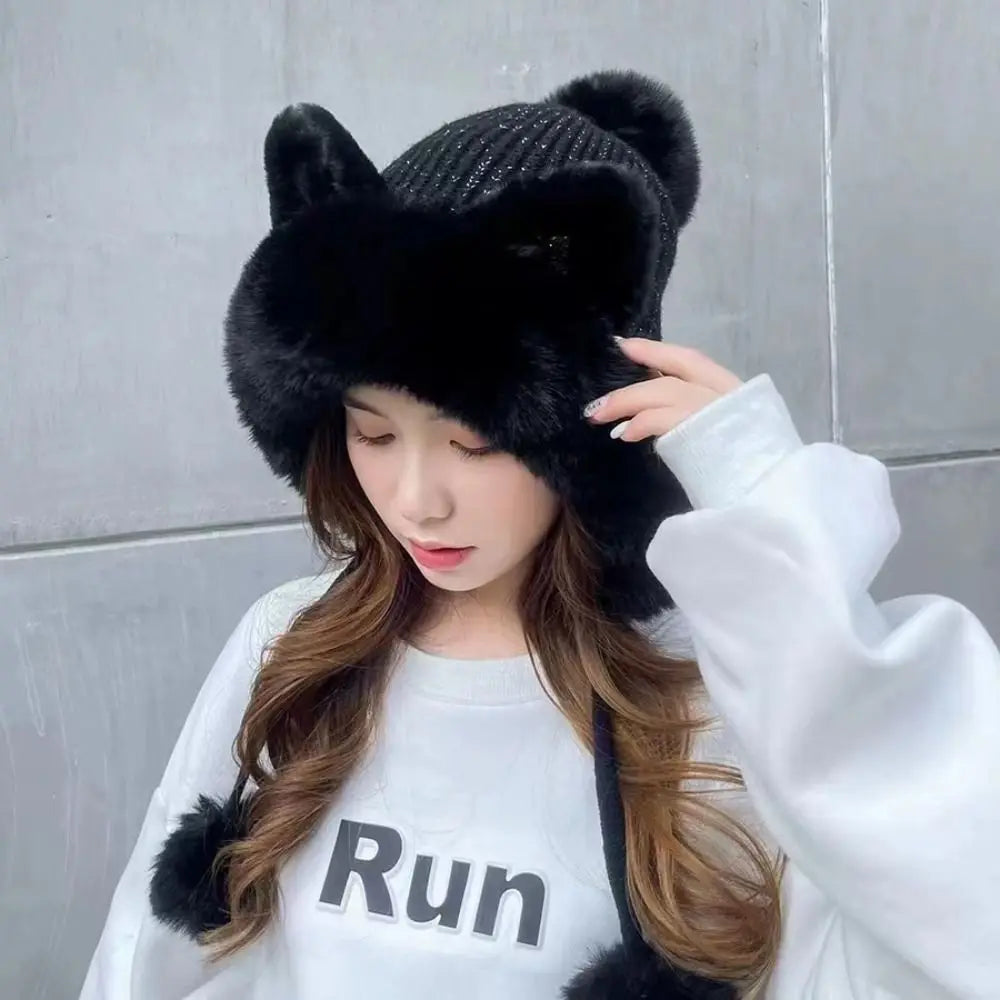 Person wearing a black fur hat with Kawaii cat ears against a gray wall.