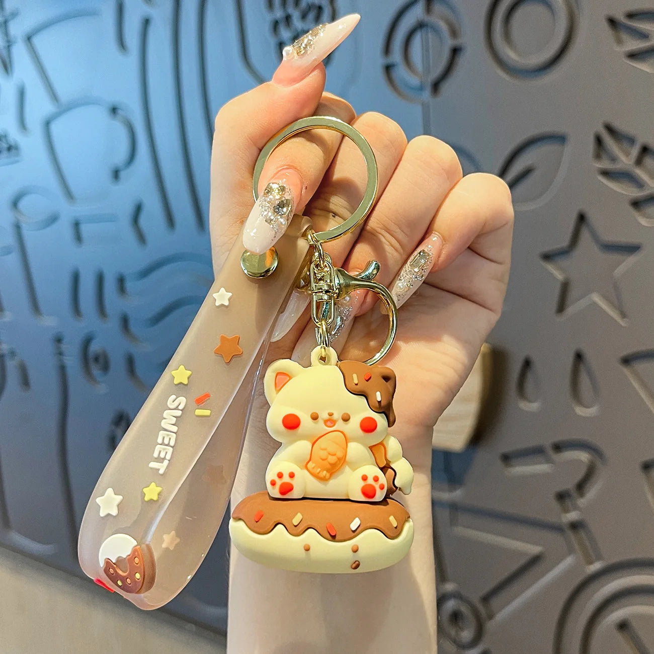 Hand holding a cute keychain with a kawaii bear design against a textured background