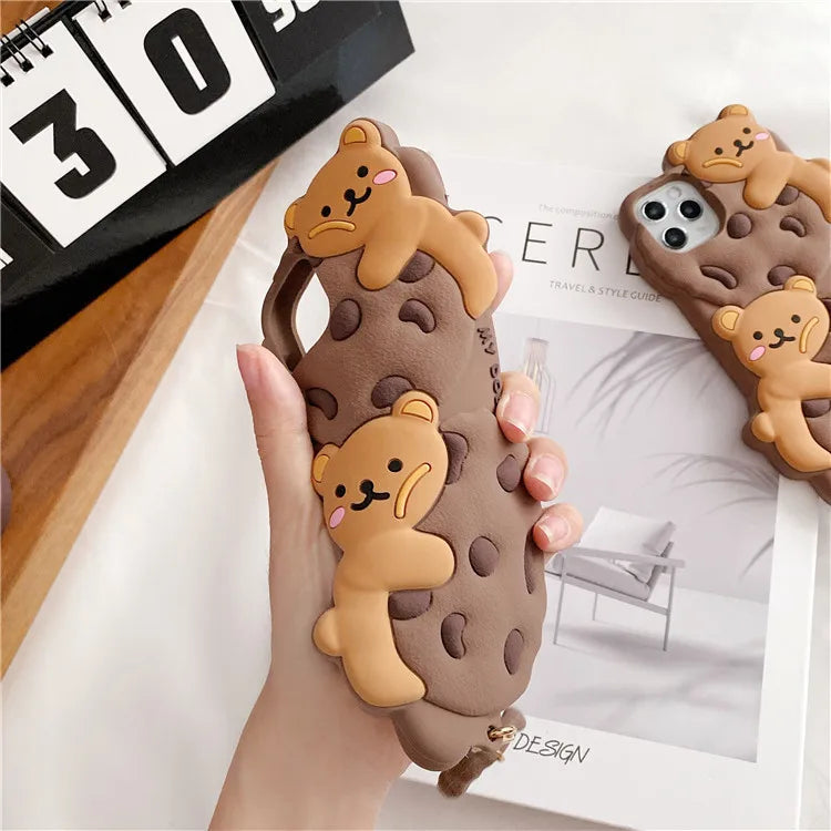 Phone case with kawaii bear design held by a hand, with another case in the background.