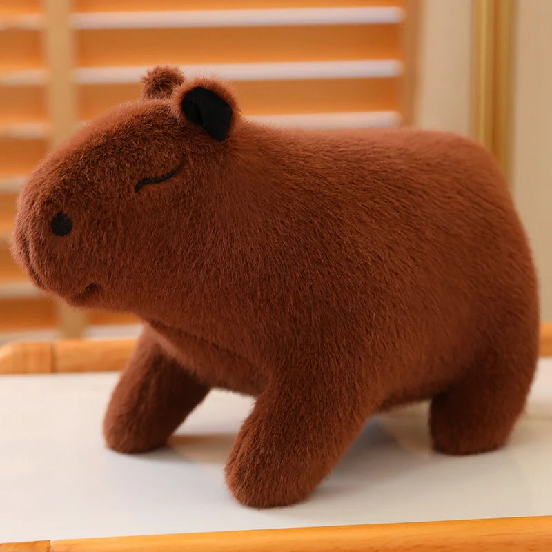 Brown kawaii plush toy resembling a capybara on a white surface with a wooden frame background