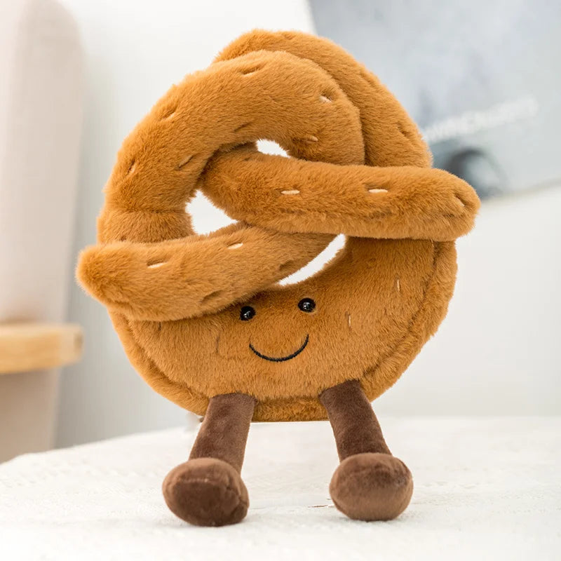 Plush kawaii toy shaped like a pretzel with a smiling face on a white surface.