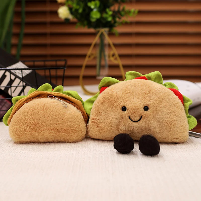 Two kawaii plush taco toys on a surface with a blurred indoor background