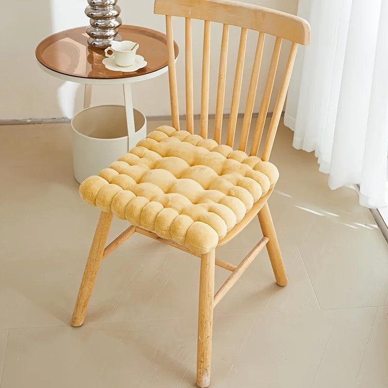 Wooden chair with a yellow kawaii cushion on a light-colored floor.