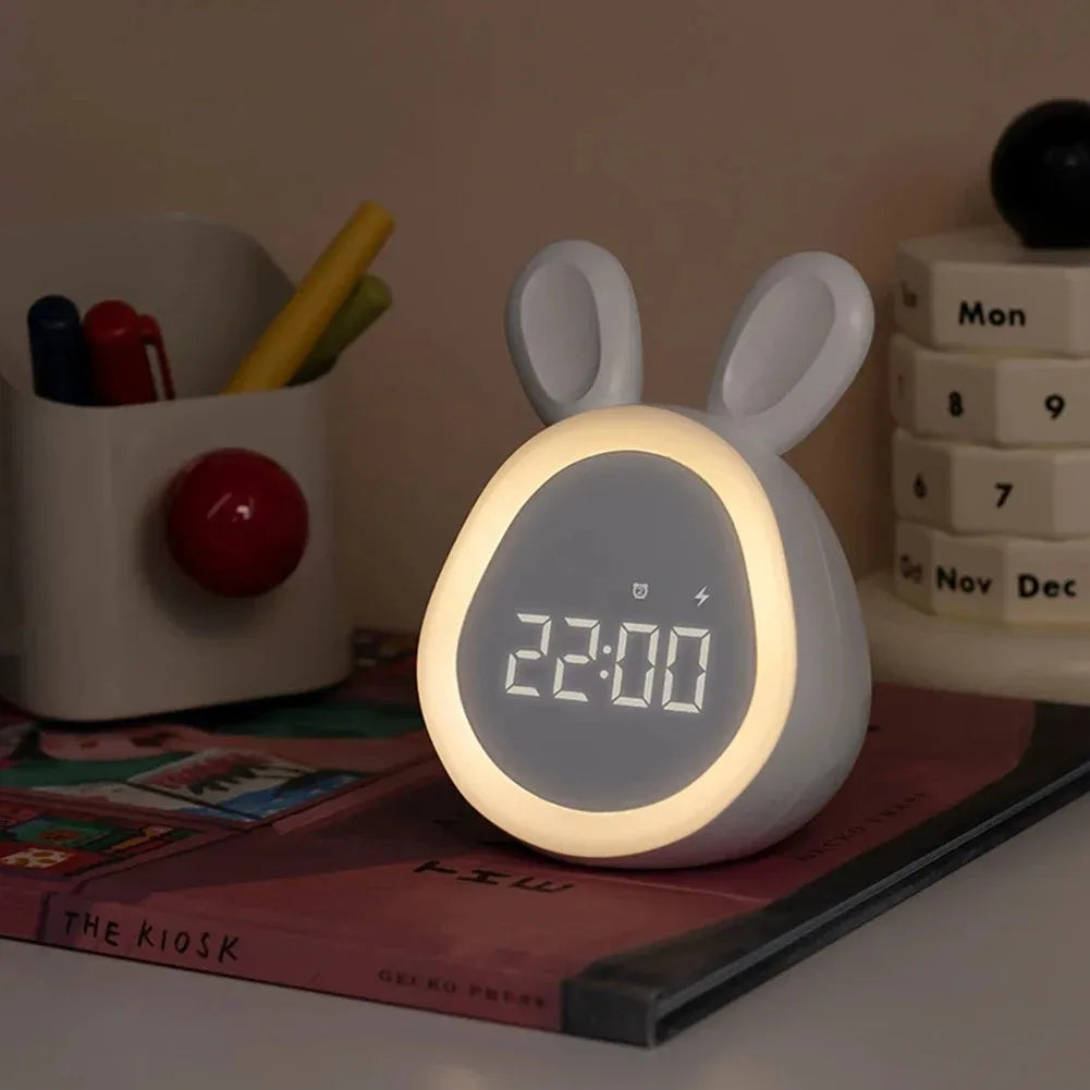 White rabbit-shaped kawaii digital clock with a glowing face on a desk.