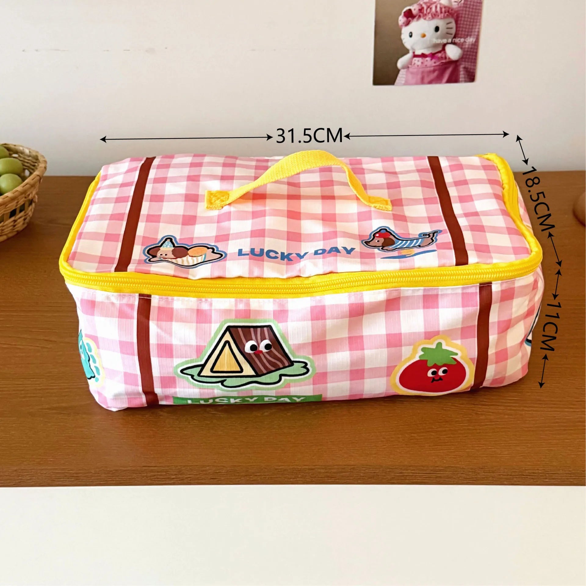 Pink checkered pouch with Kawaii cartoon designs on a wooden surface